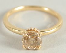 AN 18CT YELLOW GOLD FANCY SINGLE STONE RING and a band of diamonds around the shank..
