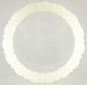 A CARVED WHITE JADE BANGLE. 3.25ins diameter.