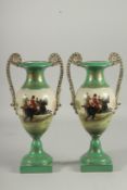 A PAIR OF SEVRES DESIGN TWO HANDLED GREEN HUNTING VASES. 13ins high.