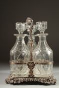 A GOOD THREE BOTTLE DECANTER STAND with three decanters and stoppers.