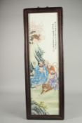 A FRAMED CHINESE LONG PORCELAIN PLAQUE with figures and calligraphy. 28ins x 8ins.