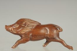 A CARVED WOOD BOAR NETSUKE. Signed.