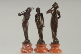 A SET OF THREE BRONZE MUSICIANS on circular marble bases 8ins.
