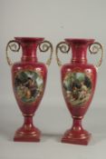 A PAIR OF SEVRES DESIGN RED PORCELAIN VASES with ovals of classical figures. 16ins high.