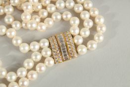 A VERY GOOD THREE ROW PEARL NECKLACE with two diamond set sections and clasp.