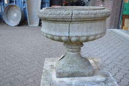 A composite circular pedestal garden planter (cracked).