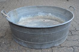 An unusual large galvanised circular twin handled garden planter.