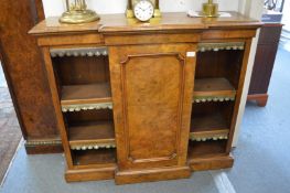 A Victorian burr walnut small breakfront bookcase with a central panelled door flanked by open