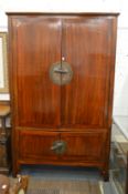 A large Chinese redwood wardrobe with two large doors above a pair of further doors.