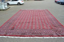 A good large modern crimson ground Bokara carpet 580cm x 380cm.