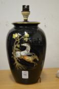 A pottery table lamp decorated with horses.