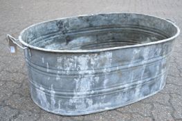 A large galvanised twin handled oval garden planter.