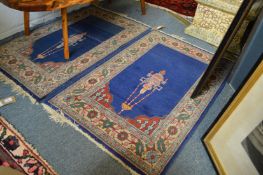 A pair of small blue ground Persian design prayer rugs each 102cm x 66cm.
