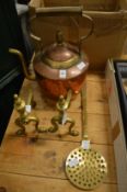 A copper and brass kettle, pair of brass fire dogs and a brass skimmer.