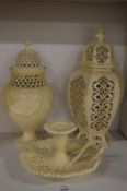 Three pieces of cream ware comprising of two vases and covers and a chamber stick.