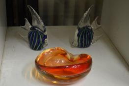 Two glass fish and an orange glass bowl.