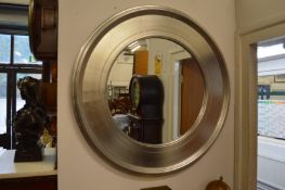 A modern circular wall mirror with silver coloured frame.
