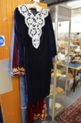 A bead decorated ladies blue velvet dress.