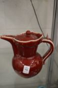 A Chinese red glazed pottery ewer.
