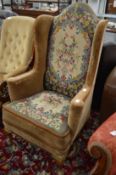 A George II style needlework upholstered high back wing armchair on cabriole legs.