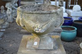 A pair of composite garden pedestal planters with swag decoration.