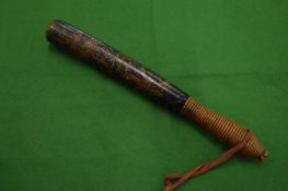 A wooden truncheon with traces of painted decoration.
