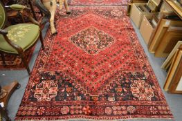 A Persian design carpet, red ground with stylised decoration (slight moth damage) 285cm x 1666cm.