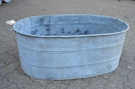 A large galvanised twin handled oval garden planter.