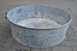 An unusual large galvanised circular twin handled garden planter.