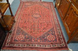 A Persian design carpet, red ground with stylised bird decoration 240cm x 155cm.