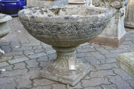 A large circular composite garden pedestal planter.