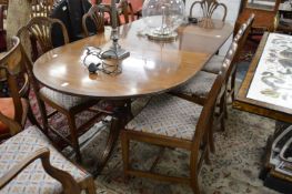A mahogany twin pedestal dining table with one leaf.