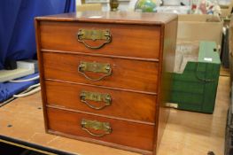 A mahogany table top four drawer chest.