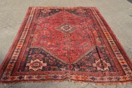 A Persian design carpet, red ground with stylised decoration 290cm x 220cm.
