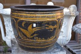 A large pottery garden planter decorated with panels and birds (cracked).