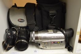 A digital camera and a camcorder with bags and accessories.