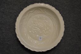 A Chinese white glazed moulded pottery circular dish.