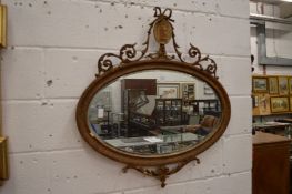 An Adam Revival oval wall mirror.