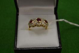 An 18ct gold ring with three clusters comprising rubies and diamonds size N.