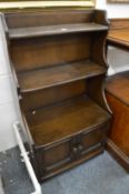 An Ercol small shelving unit with cupboards.