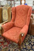 A Victorian mahogany framed and crimson upholstered high back wing armchair.