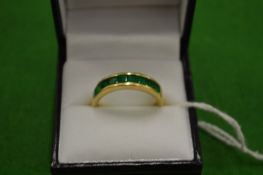 An 18ct gold ring set with 9 baguette cut treated emeralds size T.