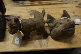 A novelty cast iron door stop modelled as a dog cocking its leg together with a cast iron fox head.