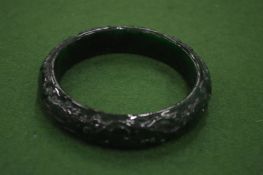 A Chinese carved green jade bangle.