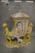A Continental porcelain jar and cover modelled as two men carrying a sedan chair with a dog by there