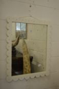 A mirror with white painted frame.