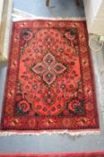 A Persian design rug, red ground with stylised floral decoration 122cm x 86cm.