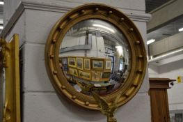 A gilt framed convex wall mirror.