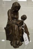 A small bronze sculpture of a seated mother and child.