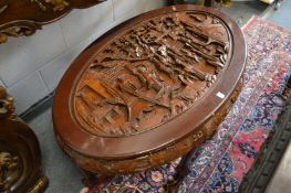 A Chinese carved wood oval coffee table.
